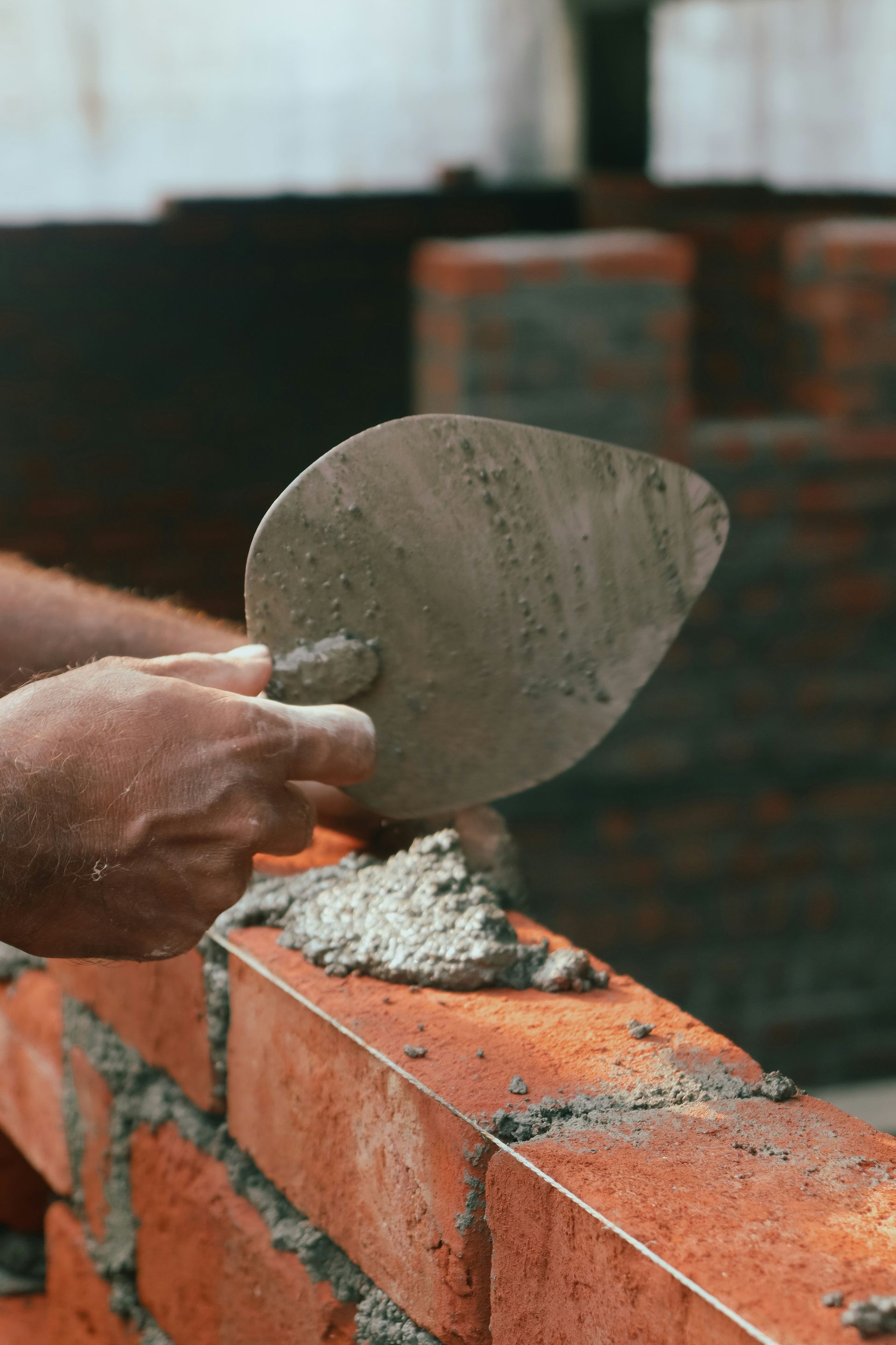 a brick wall being worked on with a trowe